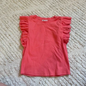 Koral topp från Zara - Säljer denna sommar topp i koral färg! Den är liten i storlek och passar mig som är S, jag skulle  absolut inte säga att den är L. Nästan aldrig använd, som ny bara att den är lite skrynklig på bilden. 
