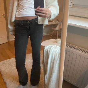 Svarta bootcut jeans med låg midja - Snygga svarta jeans med bootcut och låg midja från Gina Tricot. Jeansen har klassisk femficksdesign och är i stretchigt denimtyg som sitter tajt upptill och släpper ut vid bensluten. Perfekta till sneakers eller boots. Inga defekter, originalpris ca 499