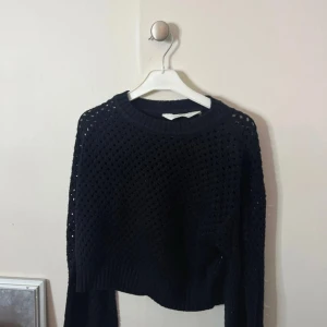 Svart stickad tröja från H&M - Svart stickad tröja från H&M med  hålmönster. Långärmad och lite croppad modell som passar perfekt till att dra över en t-shirt eller ett linne. PRIS KAN DISKUTERAS 