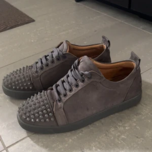 Grå Louboutin skor med spikar  - Säljer min killes gråa Louboutin skor som tidigare är köpt på Plick. Skorna har tecken på användning men är väl omhändertagen🩷