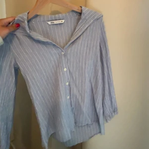 Blåvit randig skjorta/blus från Zara - Snygg blå skjorta med vita ränder från Zara . Väldigt cool och unik skjorta med lite kortare ärmar💕