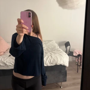 Mörkblå havt offshoulder croppad tröja - Säljer en mörkblå croppad tröja med offshoulder-design och långa ärmar. Tröjan har en lös passform och är perfekt för dig som gillar en chill och trendig stil. Materialet känns mjukt och skönt mot huden.