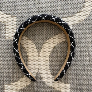 Svart och vit rutigt diadem - Snyggt vadderat diadem i svart och vitt med rutigt mönster. Ytan är i ett grovt tyg som påminner om tweed och insidan är klädd i beige mockaliknande material. 