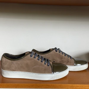 Beiga och gröna Lanvin sneakers (nyskick) - Feta Lanvin skor i beige mocka med olivgröna lackdetaljer på tå och kant. Uk size 8 som motsvarar strl 42. Använda fåtal gånger (nyskick). Extra skosnören medföljer. Hör av er vid minsta fundering!😀