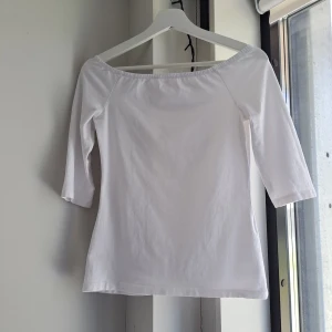 Vit topp från Even&Odd S 36 - Snygg klassisk vit offshoulder topp från Even&Odd med trekvartsärm. Gjord i mjuk bomull, perfekt för en fräsch och enkel look. Stilren och lätt att matcha med allt, passar dig som gillar minimalistiskt och trendigt. Använd en gång. Perfekt skick bortsett från att det blev "hål" när jag klippte ut lappen. 95% bomull, 5% elastan