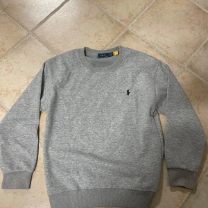 Grå sweatshirt från Polo Ralph Lauren - Säljer denna sjukt feta hoodie från Ralph luren, säljer denna då den blivit för lite. Skriv för minsta lilla fundering. Pris kan även diskuteras vid snabb affär😁 Nypris ( 1100)