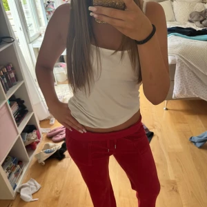 Röda Juicy byxor - Säljer mina röda juicybyxor! De är använda 1-2 gånger och är fortfarande jättemjuka! Byxorna är i modellen med fickor och har fina silverdetaljer både fram och bak. Perfekta för chill dagar eller när du vill vara bekväm men ändå se fräsch ut!
