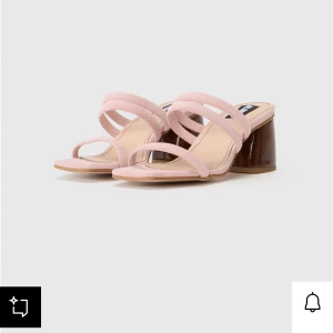 Rosa sandaler med blockklack - Snygga sandaler i ljusrosa mocka med tre tunna remmar över foten och öppen tå. Skon har en unik brun blockklack i lackad finish som ger en cool kontrast. Nypris 1595kr