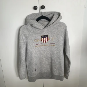 Grå hoodie från GANT med brodyr - Snygg grå hoodie från Gant. Storlek 152 men passar ända upp till 160 cm. Väldigt fint och passar till allt 
