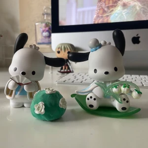 Pochacco sanrio figur - Pochacco-figurer från Sanrio, klädda i söta dräkter och med tillbehör som en solfjäder och blommor. Perfekt för dig som älskar kawaii-samlarprylar och vill dekorera ditt skrivbord med något gulligt och unikt.
