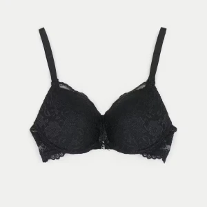 Svart push up-bh  - Snygg svart push up- bh med vadderade kupor och justerbara axelband. Hela bh:n är täckt av blommig spets. Storlek 75A