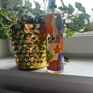 SKIL Vanilla Ice Cream Body Mist - Fräsch body & hair mist från SKIL med doft av vaniljglass, karamell och mjölkiga toner. Flaskan är transparent med färgglad design i lila, orange och grönt samt blommor och stjärnor. Rymmer 250 ml och har praktisk sprayfunktion.