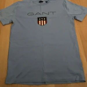 GANT T-shirt  - Säljer denna aldrig använda Gant T-shirt. Fin färg speciellt nu för sommarn. Storlek 15 år för barn men passar XS.