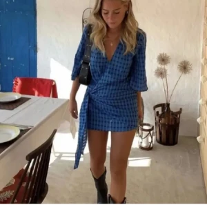 Blå omlottklänning med rutigt mönster - Säljer denna slutsålda klänning från Zara. Jag har endast använt den 1 gång men har köpt den tidigare på plick. Den är i bra skick☺️Storlek S