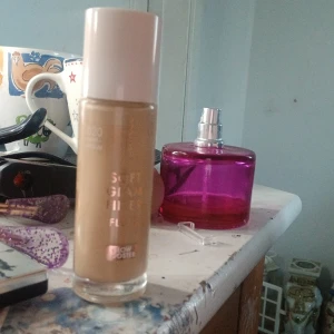 Soft Glam Filter Foundation Glow Booster - Flytande foundation från Catrice i nyansen 020 Neutral Ivory. Kommer i en glasflaska med vit skruvkork och applikator. Ger en soft glam-effekt med glow booster för en naturligt fräsch finish. Perfekt för dig som vill ha en lätt täckning och lyster.