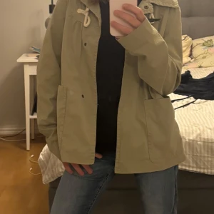 Grön jacka från Springfield - Snygg grön vår/höst jacka från Springfield med stora fickor framtill och en cool snörningsdetalj vid kragen. Ser lite stor ut då min lillasyster behövde ställa upp som modell. Står storlek 36 men skulle säga att den är som 34/xs, skriv om det är några funderingar!!💗