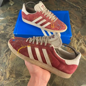 Custom made Adidas gazelle skor - Tja! Säljer nu mina egen designade rödvina adidas gazelle skor! Skorna är i storlek 39 1/3. En sitter som storlek 40. Dessa skor är ja riktigt stolt över men känner att det är dags att renovera garderoben nu🙃Hör gärna av dig vid frågor eller prisförslag! (Ta hand om dessa varsamt🤒)