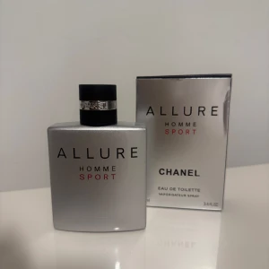 Chanel Allure Homme Sport 100ml - Chanel Allure Homme Sport Eau de Toilette, 100 ml. Snygg silverfärgad flaska med svart kork och metallisk detalj. Doften är fräsch och sportig, perfekt för dig som gillar en energisk och modern stil. Kommer med originalkartong i matchande silver.
