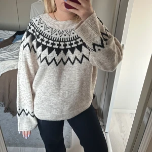 Beige stickad tröja med svart mönster - Supermysig beige stickad tröja med svart  mönster över bröstet och ärmsluten, aldrig använd. 
