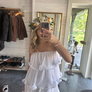 Vit volangklänning med tunna axelband - Supersöt vit kortklänning med tunna axelband och volanger. Klänningen har en luftig och flowy känsla, perfekt för sommarens alla tillfällen. Köpt för 799 och endast använt en gång🩷