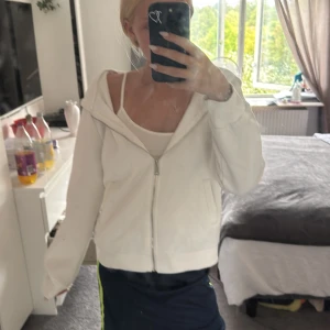 Vit hoodiejacka med dragkedja - Vit hoodiejacka med dragkedja framtill och stor huva. Jackan har en avslappnad passform och är tillverkad i mjukt bomullsmaterial. Perfekt för chill dagar eller när du vill ha en enkel och clean look. 💕