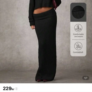 Svart ribbad stickad långkjol - Svart långkjol i ribbstickat material med bred, vikt linning. Kjolen är figurnära och har en mjuk, stretchig känsla som gör den superbekväm. Perfekt till chunky sneakers eller boots och en croppad tröja.