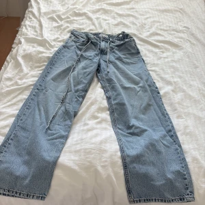 Wide jeans från Gina Tricot, ljusblå - Säljer ett par ljusblå wide jeans från Gina Tricot i storlek 34. Byxorna har hög midja, raka och vida ben samt coola sömdetaljer framtill. Klassisk femficksmodell och tillverkade i bomull. Perfekta för en avslappnad och trendig look.