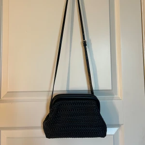 Svart axelväska med flätad look - Säljer en svart axelväska som är flätad, använd fåtal gånger