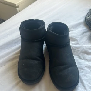 Svarta boots från Nelly med foder - Mysiga svarta boots från Nelly med rund tå och mjukt foder på insidan. Skorna har en platt sula och är perfekta för kalla dagar. Utsidan är i mockaliknande material och de har en enkel, stilren design som passar till det mesta.