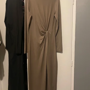  långklänning  - Helt ny, aldrig använt, beige långklänning från Kappahl i mjukt material med snygg twistdetalj framtill. Klänningen har långa ärmar och rak passform.