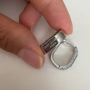 YVL  - Snygga örhängen från Paris i silverfärg med glittrande stenar på framsidan. Rektangulär form och klassisk design på sidan. Perfekta för dig som vill ha en lyxig touch till din stil.