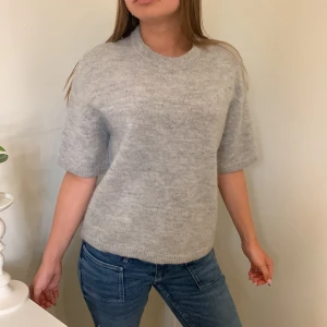 Ljusgrå stickad tröja 🌻 -  ljusgrå stickad tröja från Selected Femme med kort ärm och rund halsringning. Tröjan har en relaxed fit och ribbade kanter vid ärmslut och nederkant. Perfekt att styla med jeans eller kjol. Tröjan är lite stickig då den är stickad så bra om man ej är så känslig för de💓💓