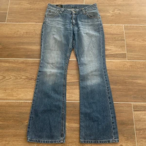 Lågmidjade utsvängda jeans  - Ett par lågmidjade jeans från lee i storlek 30-31. Osäker om de är en M/L, utgå från officiell storlek på lappen och måtten. Jeansen är i mycket fint skick och inga defekter. Rakt över midjemått: 38cm. Innebenslängd: 77cm. Total längd: 102cm. Gren: 21cm. Benslut: 23cm. D32