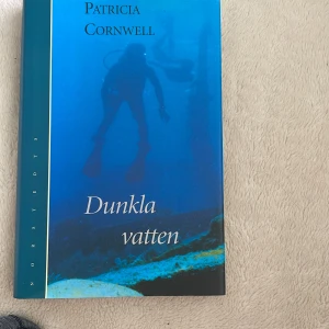 Dunkla vatten - En spännande deckare där rättsläkaren Kay Scarpetta utreder ett mystiskt dödsfall under vattenytan. Perfekt för dig som gillar nervkittlande mordgåtor och smarta utredningar. Patricia Cornwell levererar ännu en bladvändare för unga vuxna och deckarfans.