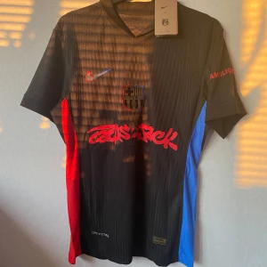 FC Barcelona x Cactus Jack – Lamine Yamal #19 (S) - Säljer en ny och oanvänd matchtröja från det unika samarbetet mellan Barcelona och Cactus Jack (Travis Scott). 🔥tagg finns och går att scanna 📏 Storlek: S 💯 Tryck: Lamine Yamal #19 + UNHCR-logga ✔️ Svart design med röd/blå detaljer – limited edition!  Skickas snabbt. Skriv vid intresse!