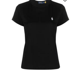 Svart t-shirt från Polo Ralph Lauren - Klassisk svart t-shirt från Polo Ralph Lauren med vit broderad logga på bröstet. T-shirten har rund halsringning och korta ärmar. Snygg och enkel modell som passar till allt. Tillverkad i mjuk bomull för maximal komfort.
