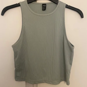 Ljusgrön ribbad linnetopp från SHEIN - Snygg ljusgrön ribbad linnetopp från SHEIN i storlek M. Toppen är ärmlös med rund halsringning och har en croppad passform. Perfekt för varma dagar och enkel att matcha med jeans eller kjol.