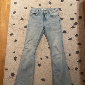 Ljusblå bootcut jeans från Gina Tricot - Säljer ett par ljusblå bootcut jeans från Gina Tricot, modell Perfect Jeans. De har klassisk femficksdesign, ganska låg midja