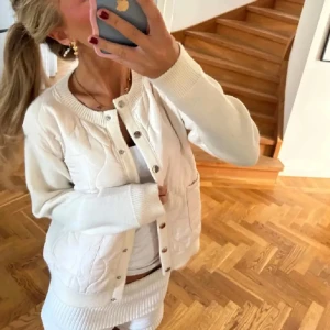 Vit quiltad cardigan jacka från Graciela - Säljer en vit cardigan jacka från Graciela med quiltad framsida och stickade ärmar då den tyvärr inte passade mig. Jackan har rund halsringning, knappar framtill och ribbade muddar. Perfekt för lager-på-lager och en clean look.