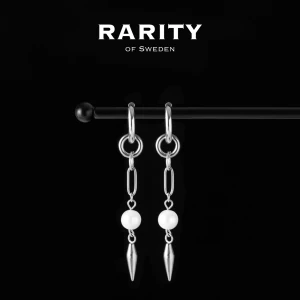 Aurora Earring - Silver: Silverörhängen med pärlor och nitar - Snygga silverörhängen från Rarity of Sweden med kedjedetaljer och vita pärlor. Hängande design med spetsiga silverdroppar längst ner ger en cool och modern vibe. Perfekt för dig som gillar att sticka ut med dina accessoarer.