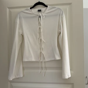 Vit snörad topp från Gina Tricot - Vit långärmad topp från Gina Tricot i bomull. Använd en gång, finns katt i hemmet.