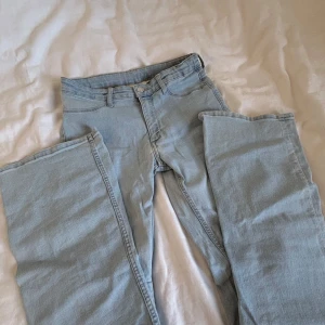 Ljusblå flared jeans från H&M - Säljer ett par ljusblå jeans från H&M med flared ben och låg midja. Jeansen har justerbar midja, klassiska fem fickor och är tillverkade i mjukt denimtyg. Säljer då jag har för mycket kläder i garderoben💕 