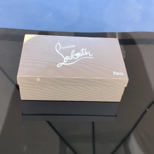 Mörkblå sneakers från Christian Louboutin - Exklusiva mörkblå sneakers från Christian Louboutin i mocka med ikonisk röd sula och broderad logga på hälen. Snygg och stilren design med rund tå och platt sula. Kommer med originalkartong, dustbag och äkthetskort.