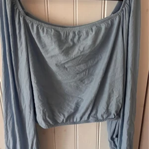 Ljusblå offshoulder topp - Säljer en ljusblå offshoulder topp från Cubus i storlek L. Köpt för ungefär två år sedan men har inte blivit använd så mycket. Den är mer som M med tanke på att den är ganska kort men passar säkert L också