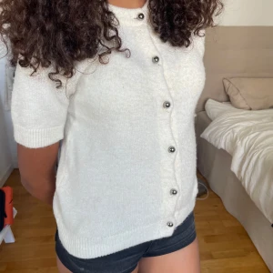 stickad kortärmad kofta - säljer denna sjukt fina kortärmade kofta från gina!! bara använd ett fåtal gånger och är i bra skick! skickar även med extraknappar! priset kan diskuteras