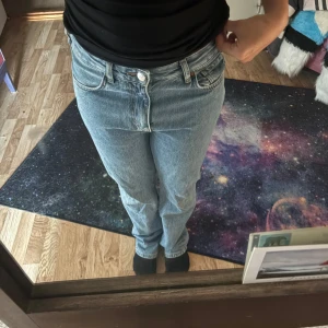 Blå low waist straight jeans 28/30 - Säljer ett par ljusblå jeans med låg midja och raka ben. Klassisk femficksmodell i denim med snygg tvätt och enkel knappstängning. Perfekta för dig som gillar en avslappnad och tidlös look.