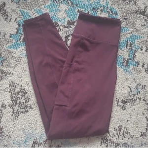 Röda tights från HM - Träningsbyxor från HM i strl S. Vinröda med ficka på höger lår, perfekt för mobilen. Sömmen lite sliten på baksidan, men inget som märks. Annars i bra skick. Hög midja som inte glider ner och går ner till fotlederna. Säljer matchande sportbh från ICIW också.