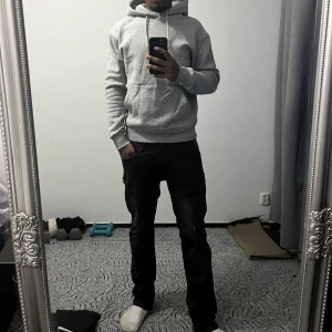 Grå hoodie  - Enkel och clean grå hoodie med huva och snören. Tröjan har en normal passform och är långärmad, perfekt för höst/vinter. Materialet är av mjuk bomull och den har en klassisk look utan tryck eller mönster.