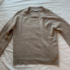 Beige stickad tröja från ONLY - Säljer en beige stickad tröja från ONLY i storlek M. Tröjan har rund halsringning, ribbade muddar och är långärmad. Materialet är mjukt och skönt, perfekt för kyliga dagar. Enkel och stilren design som funkar till jeans eller kjol.