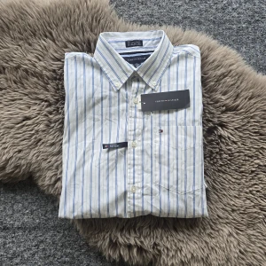 Tommy Hilfiger Skjorta - Helt ny blåvit randig skjorta från Tommy Hilfiger i storlek xs. Hör av dig om du har några frågor 📩 OBS! Finns en liten fläck vilket syns på sista bilden, men den är knappt märkbar.